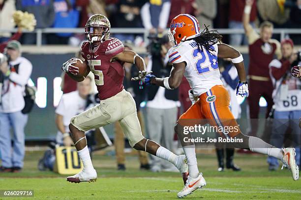Travis Rudolph of the Florida State Seminoles outruns Marcell Harris of the Florida Gators for a 46-yard touchdown in the third quarter of the game...