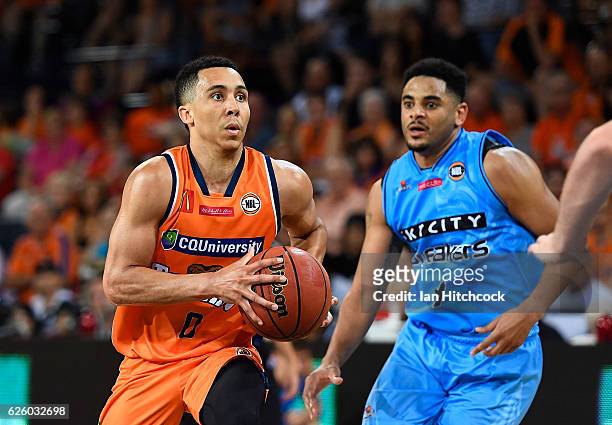 Travis Trice of the Taipans drives past Corey Webster of the Breakers during the round eight NBL match between the Cairns Taipans and the New Zealand...
