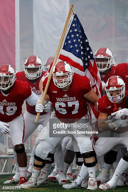 Indiana Hoosier offensive lineman Dan Feeney carries the American Flag prior to running out on the field during an NCAA football game between the...