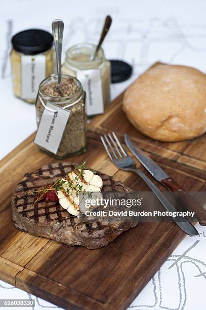 grilled steak on board with condiments - grainy mustard stock pictures, royalty-free photos & images