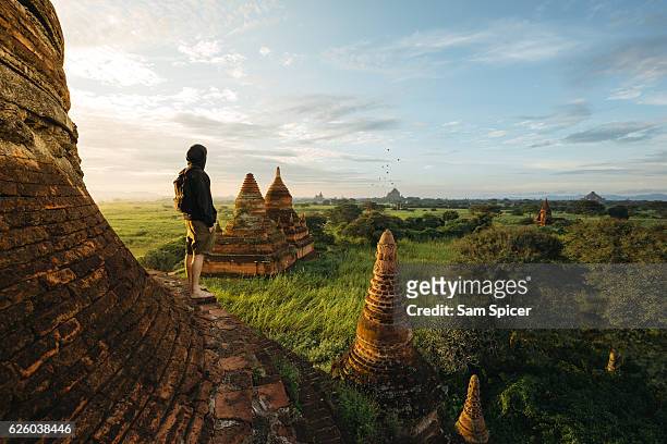 Tourist standing on Bagan Pagoda during sunrise in Myanmar