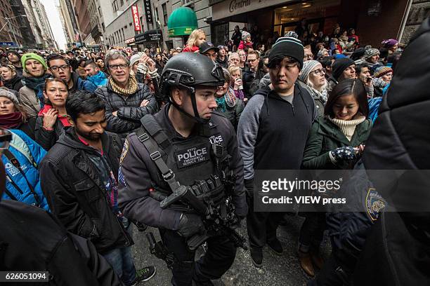 Armed police walk into the crowd as people watch the 90th annual Macy's Thanksgiving Day Parade on November 24, 2016 in New York City.