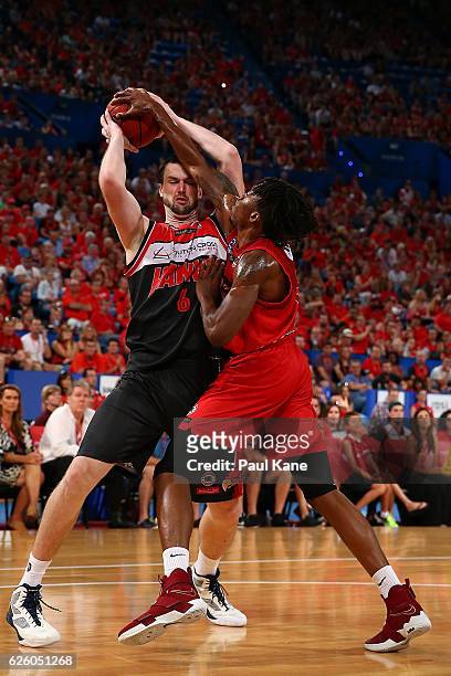 Jaron Johnson of the Wildcats attempts to block a pass by Andrew Ogilvy of the Hawks during the round eight NBL match between the Perth Wildcats and...