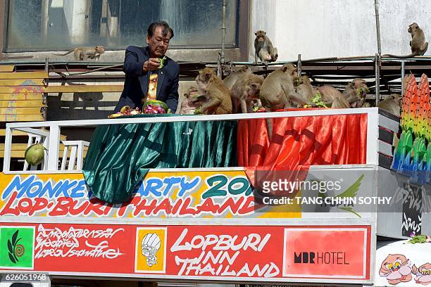 President of Lopburi Inn resort Yongyuth Kitwatananusont offers fruits and vegetables to monkeys near an ancient temple during the annual "monkey...