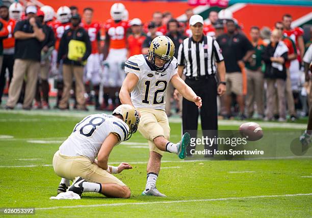 Pittsburgh Panthers Kicker Chris Blewitt kicks the ball as Pittsburgh Panthers Punter Ryan Winslow holds the ball during the NCAA football game...