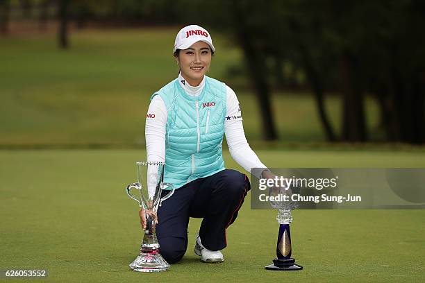 Ha-Neul Kim of South Korea poses with the Championship's trophy and sponsor's Ricoh Cup trophy during a ceremony following the LPGA Tour Championship...