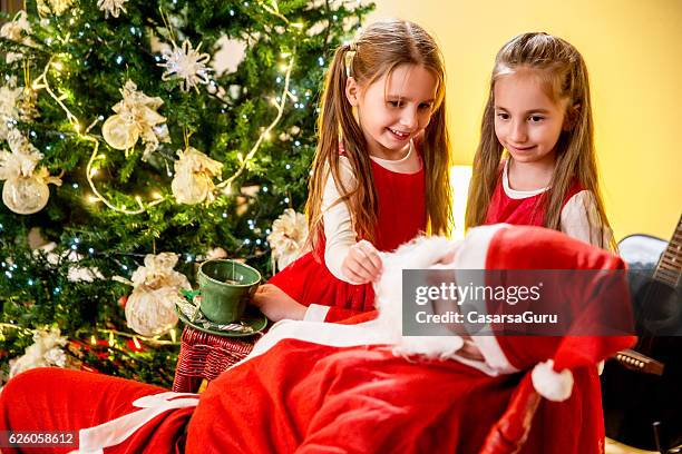 curious little girls teasing santa - naughty santa 個照片及圖片檔