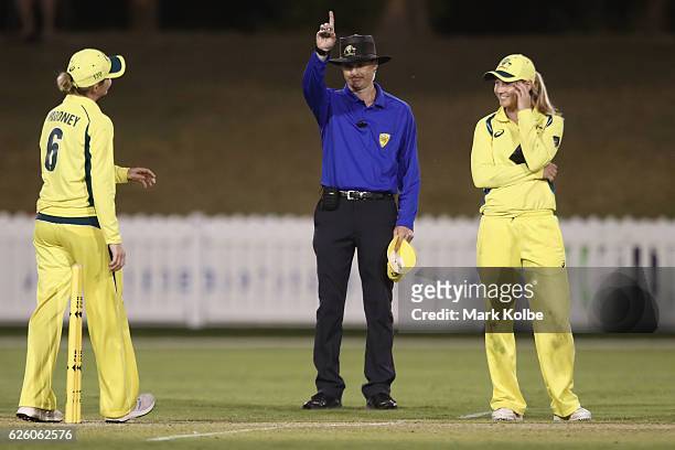 Umpire Phillip Gillespie raises his finger as Beth Mooney and Meg Lanning of Australia react after Masabata Klaas of South Africa was run out on the...