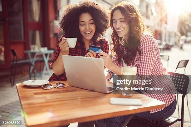 girls drinking coffee and shopping online - spending money stock pictures, royalty-free photos & images