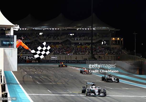 Lewis Hamilton of Great Britain and Mercedes GP crosses the line to win the race, behind is second placed finisher Nico Rosberg of Germany and...
