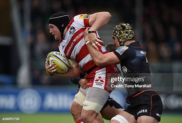 Kelly Brown and Richard Wigglesworth of Saracens tackle Ben Morgan of Gloucester Rugby during the Aviva Premiership match between Saracens and...