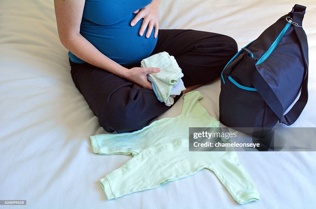 Pregnancy - pregnant woman packing a Hospital Bag