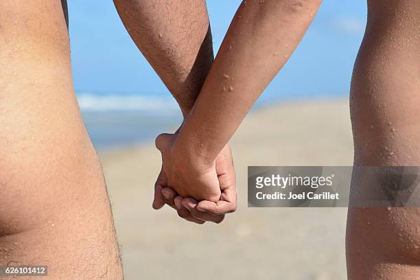 nude couple holding hands on playalinda beach in florida - bare bum 個照片及圖片檔
