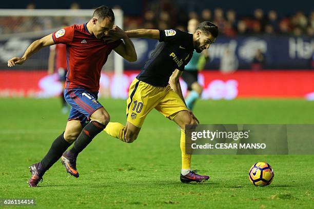 Osasuna's defender Unai Garcia vies with Atletico Madrid's Belgian midfielder Yannick Ferreira Carrasco during the Spanish league football match CA...