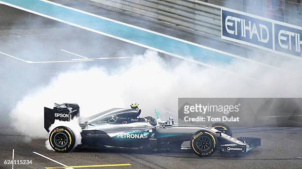 Nico Rosberg of Germany and Mercedes GP does donuts on track after finishing second and securing the F1 World Drivers Championship during the Abu...