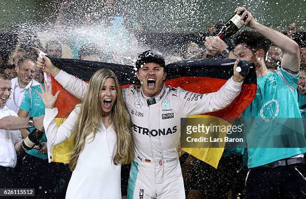 Nico Rosberg of Germany and Mercedes GP celebrates with his wife Vivian Sibold and his team after finishing second and securing the F1 World Drivers...