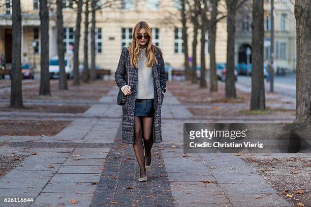 Sofia Grau wearing a black plaid checked Urban Outfitters wool coat, a white creme &other stories jumper, a black h&m pvc mini skirt, black net...