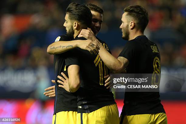 Atletico Madrid's Belgian midfielder Yannick Ferreira Carrasco celebrates with teammates during the Spanish league football match CA Osasuna vs Club...