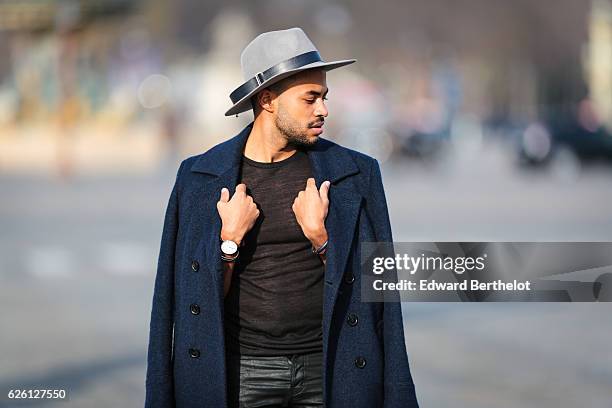 Theo Kimbaloula , is wearing a Sand Copenhagen mesh t-shirt, The Kooples black jeans, Keiro black shoes, a Daniel Wellington watch, a Saudade Paris...