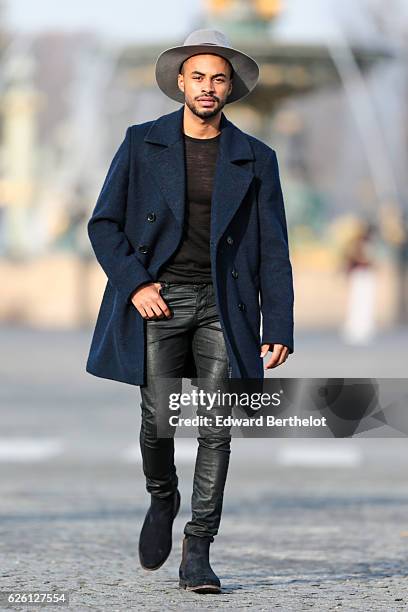 Theo Kimbaloula , is wearing a Sand Copenhagen mesh t-shirt, The Kooples black jeans, Keiro black shoes, a Daniel Wellington watch, a Saudade Paris...