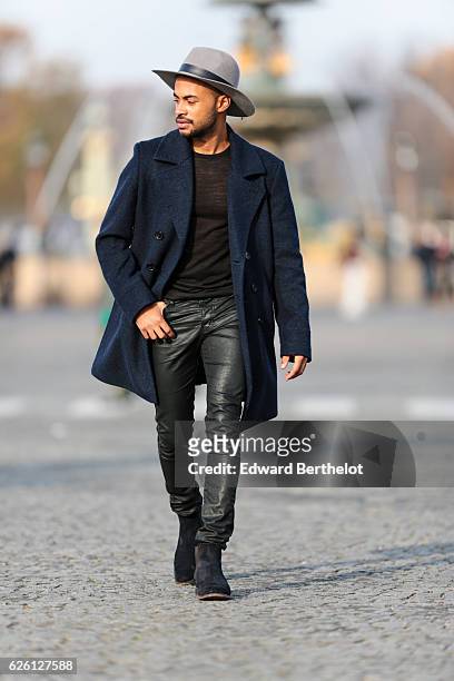 Theo Kimbaloula , is wearing a Sand Copenhagen mesh t-shirt, The Kooples black jeans, Keiro black shoes, a Daniel Wellington watch, a Saudade Paris...