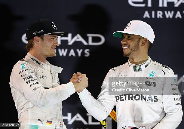 Race winner Lewis Hamilton of Great Britain and Mercedes GP shakes hands with second place finisher and F1 World Drivers Champion Nico Rosberg of...