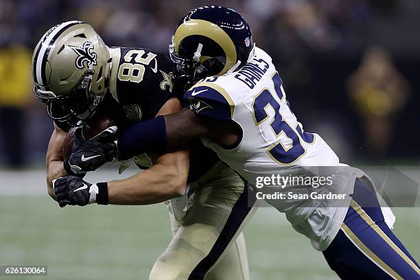 Coby Fleener of the New Orleans Saints is tackled by E.J. Gaines of the Los Angeles Rams during the first half of a game at the Mercedes-Benz...