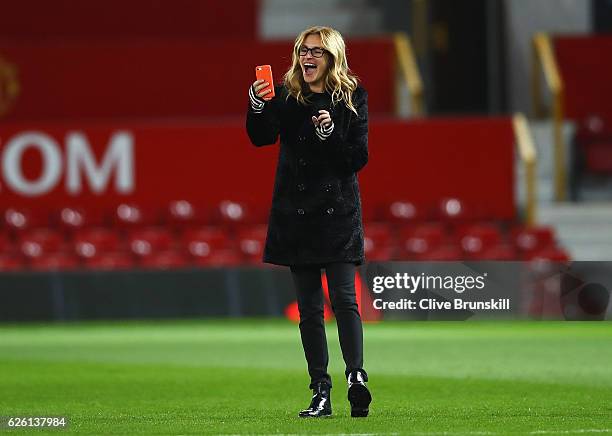 Actress Julia Roberts takes photos on the pitch after the Premier League match between Manchester United and West Ham United at Old Trafford on...