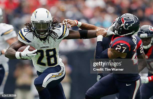 Melvin Gordon of the San Diego Chargers gives a stiff arm to Quintin Demps of the Houston Texans in the second quarter at NRG Stadium on November 27,...