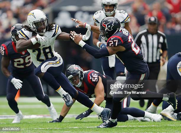 Melvin Gordon of the San Diego Chargers gives a stiff arm to Quintin Demps of the Houston Texans in the second quarter at NRG Stadium on November 27,...