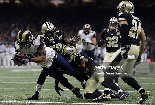 Lance Kendricks of the Los Angeles Rams scores a touchdown as Dannell Ellerbe of the New Orleans Saints and Vonn Bell defend during the first half of...