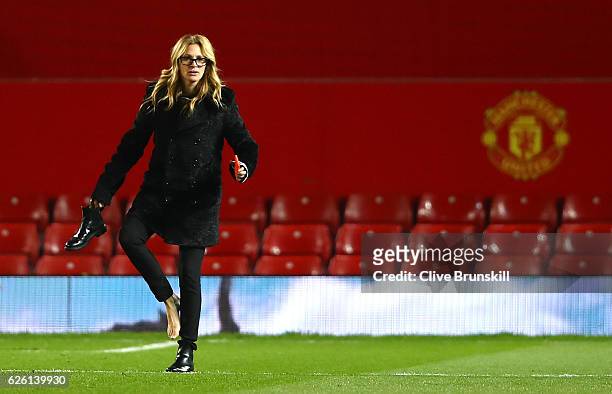 Actress Julia Roberts takes off her shoe on the pitch after the Premier League match between Manchester United and West Ham United at Old Trafford on...