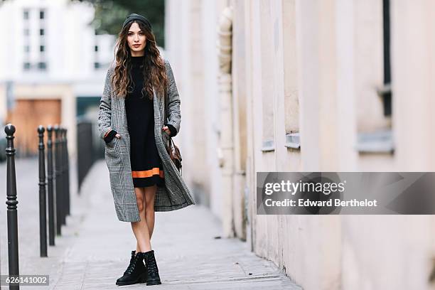 Sofya Benzakour , is wearing an Asos black dress with orange lines, an H&M gray long coat, River Island black boots, and a C&A brown bag, in the area...