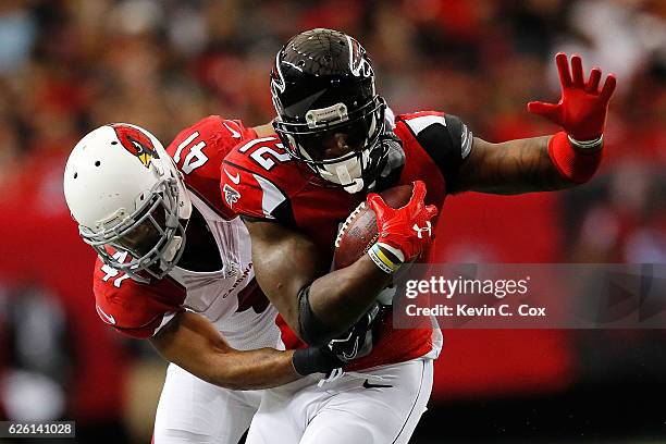 Desmond Trufant of the Atlanta Falcons is tackled by Marcus Cooper of the Arizona Cardinals during the first half at the Georgia Dome on November 27,...