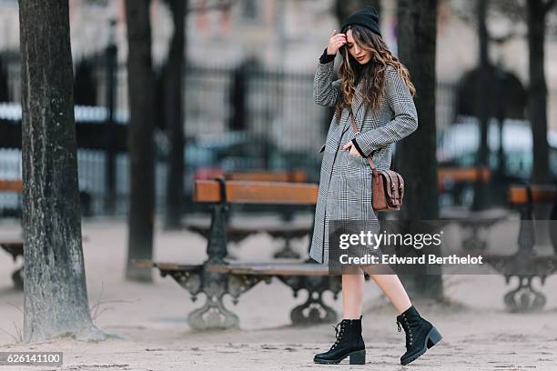 Sofya Benzakour , is wearing an Asos black dress with orange lines, an H&M gray long coat, River Island black boots, and a C&A brown bag, in the area...