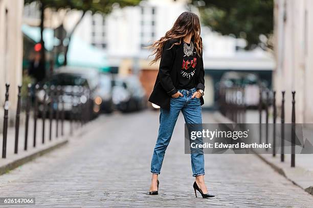 Sofya Benzakour , is wearing a Zara t-shirt with the AC-DC rock band logo, Reiko blue denim jeans, Zara black heels shoes, a Tobi black jacket, a...