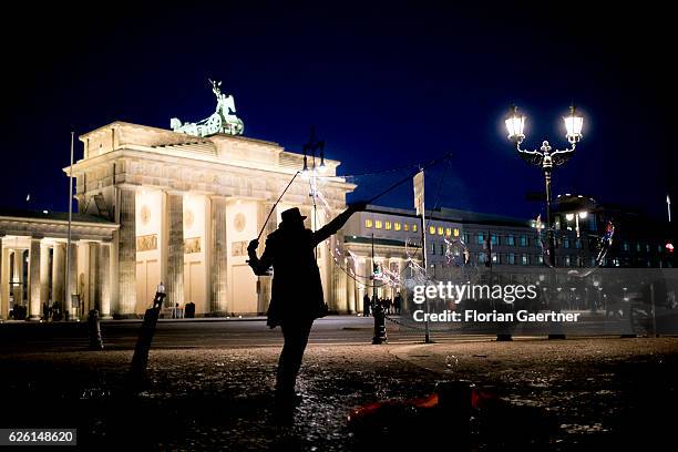 Street artist makes soap bubbles in front of the Brandenburg Gate on November 27, 2016 in Berlin, Germany.