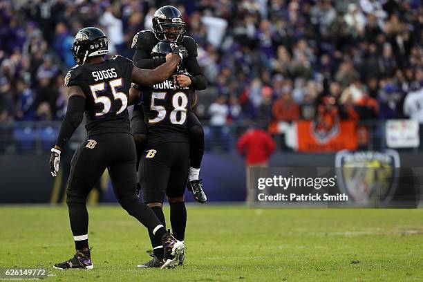 Outside linebacker Elvis Dumervil of the Baltimore Ravens reacts with teammates Strong safety Eric Weddle and outside linebacker Terrell Suggs after...