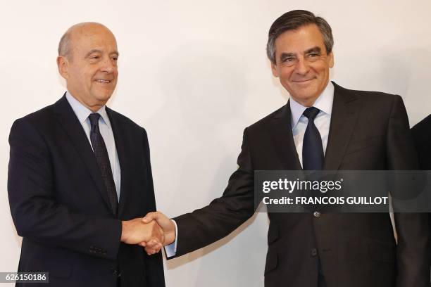 Winner of the right-wing primaries ahead of France's 2017 presidential elections, Francois Fillon shakes hands with mayor of Bordeaux and defeated...