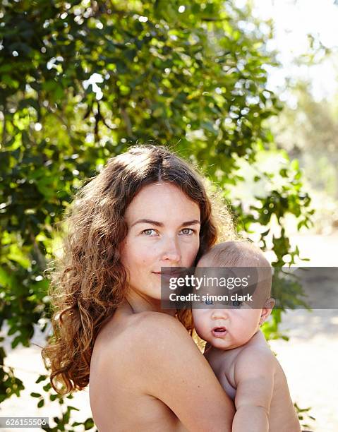 mother and son embrace in nature - baby lachen natur stock-fotos und bilder