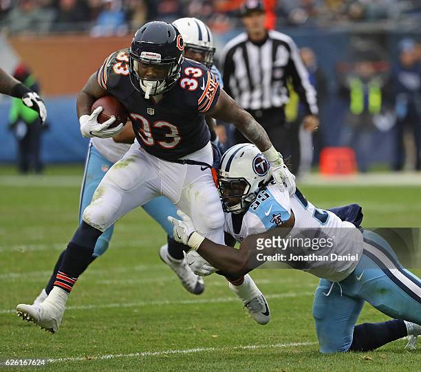 Jeremy Langford of the Chicago Bears gets tripped up by Sean Spence of the Tennessee Titans at Soldier Field on November 27, 2016 in Chicago,...