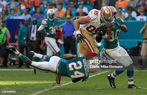 Vance McDonald of the San Francisco 49ers is tackled by Isa Abdul-Quddus of the Miami Dolphins during a game on November 27, 2016 in Miami Gardens,...