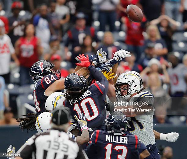 Ryan Griffin of the Houston Texans and DeAndre Hopkins of the Houston Texans battle with Kyle Emanuel of the San Diego Chargers for a pass in the...