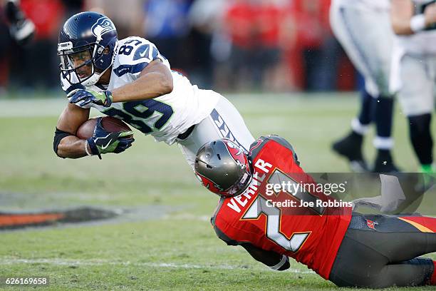 Alterraun Verner of the Tampa Bay Buccaneers tackles Doug Baldwin of the Seattle Seahawks in the second quarter of the game at Raymond James Stadium...