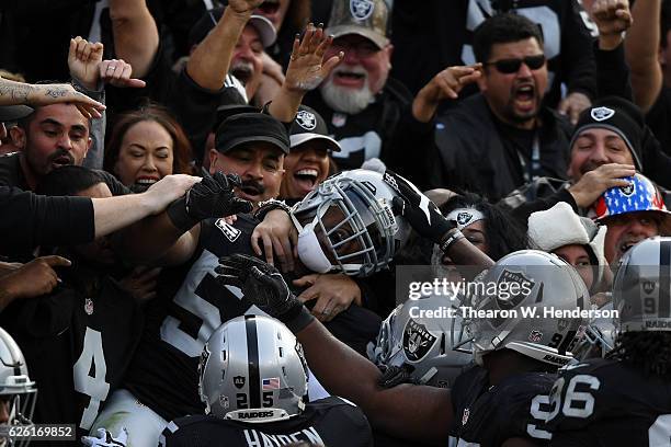 Khalil Mack of the Oakland Raiders celebrates in the stands after scoring on an interception of Cam Newton of the Carolina Panthers in the second...