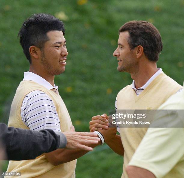 United States - Japanese golfer Hideki Matsuyama and his playing partner Adam Scott of Australia shake hands after defeating Jason Dufner and Zach...