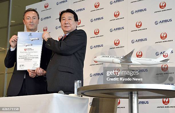 Japan - Yoshiharu Ueki , president of Japan Airlines Co., and Fabrice Bregier, chief executive officer of Airbus S.A.S., hold a contract document on...