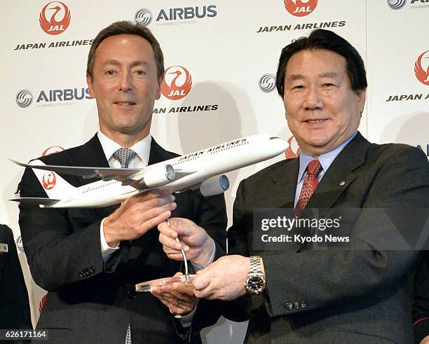 Japan - Yoshiharu Ueki , president of Japan Airlines Co., and Fabrice Bregier, chief executive officer of Airbus S.A.S., hold a JAL jetliner model...