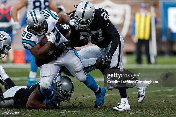 Jonathan Stewart of the Carolina Panthers is hit by Reggie Nelson of the Oakland Raiders during their NFL game on November 27, 2016 in Oakland,...