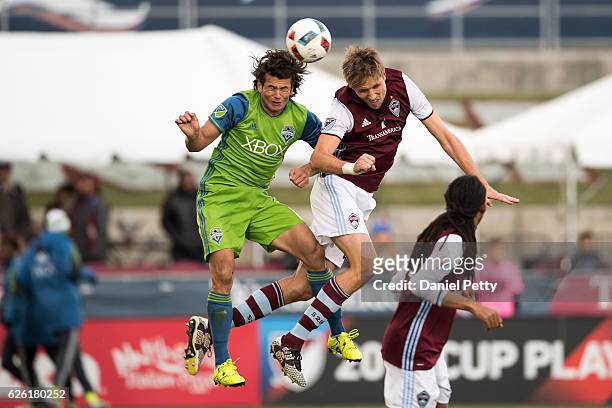 Nelson Haedo Valdez of the Seattle Sounders and Axel Sjoberg of the Colorado Rapids leap to head the ball during the second half of the second leg of...